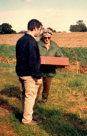 Chris hands the coffin to Mel to take onto site.